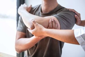 Patient discusses back pain and treatment options with a chiropractor in a bright clinical office.